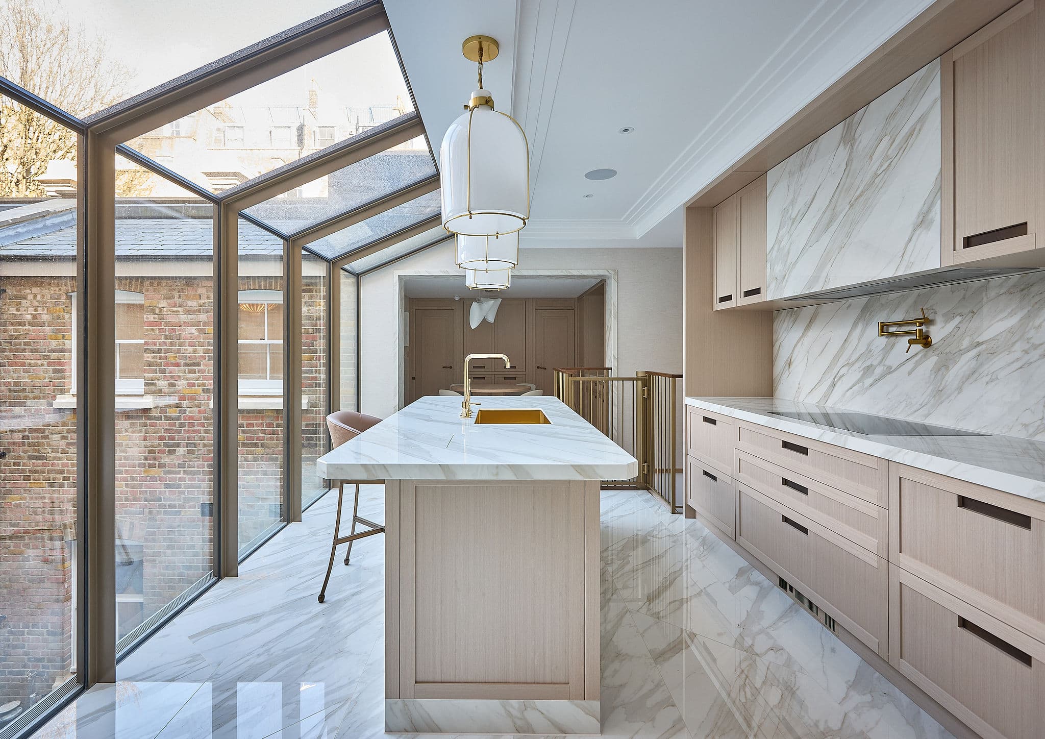 High-end residential kitchen extension with a marble island and glazed roof